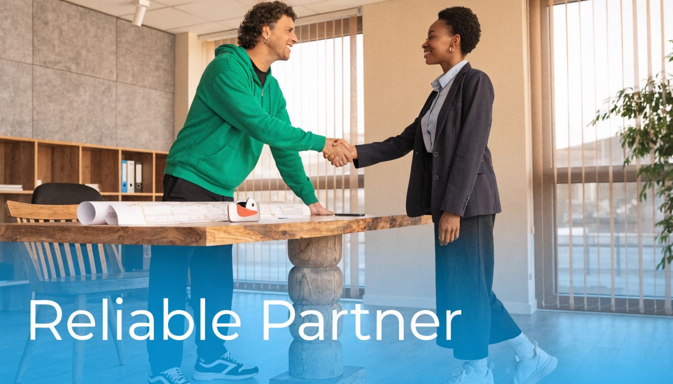 A man and a woman shaking hands over a professional work desk during a business partnership meeting.