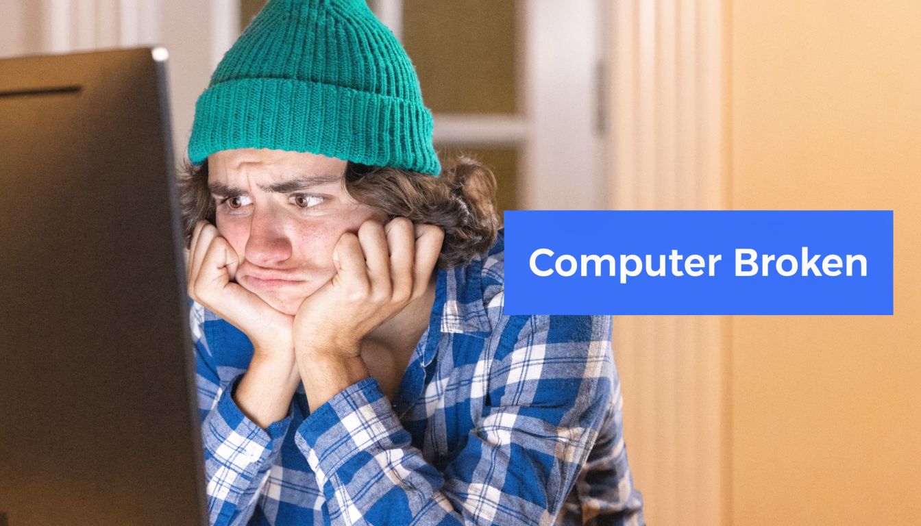 A frustrated young man wearing a green beanie sitting at a computer looking distressed and overwhelmed.